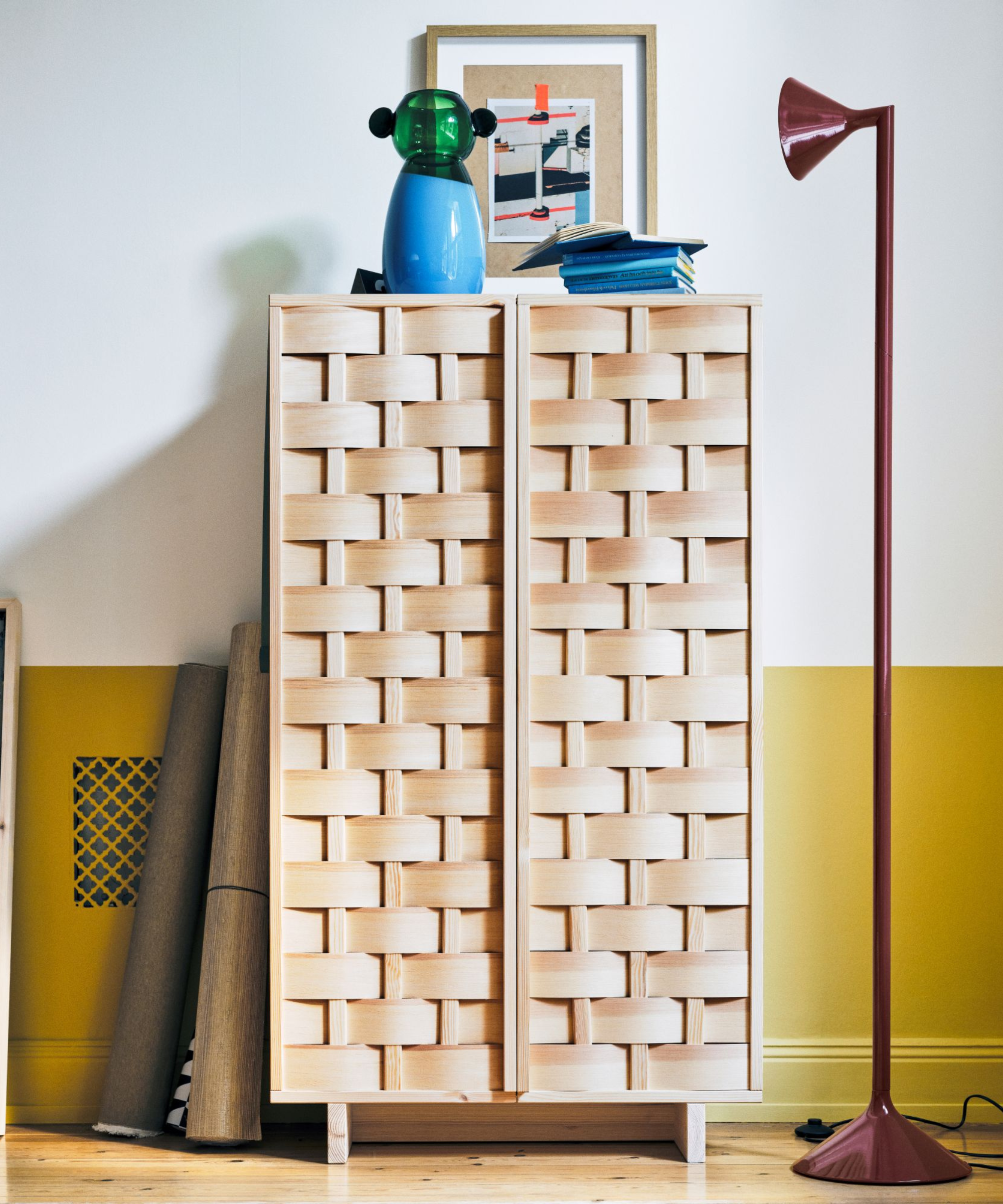 a woven wood cabinet, a floor lamp, and decor from IKEA's PS collection