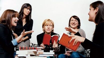 women around a table full of books