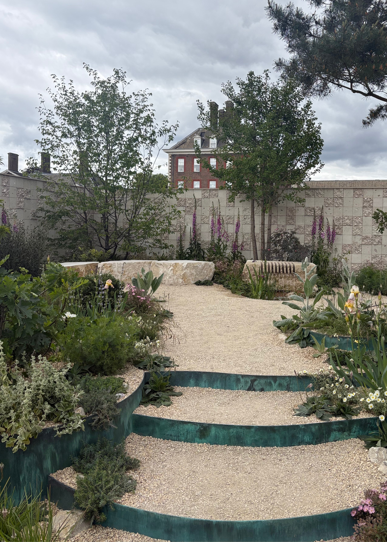 A sensory garden with layered planting, stone benches, and oystercrete walls at the Chelsea Flower Show 2026
