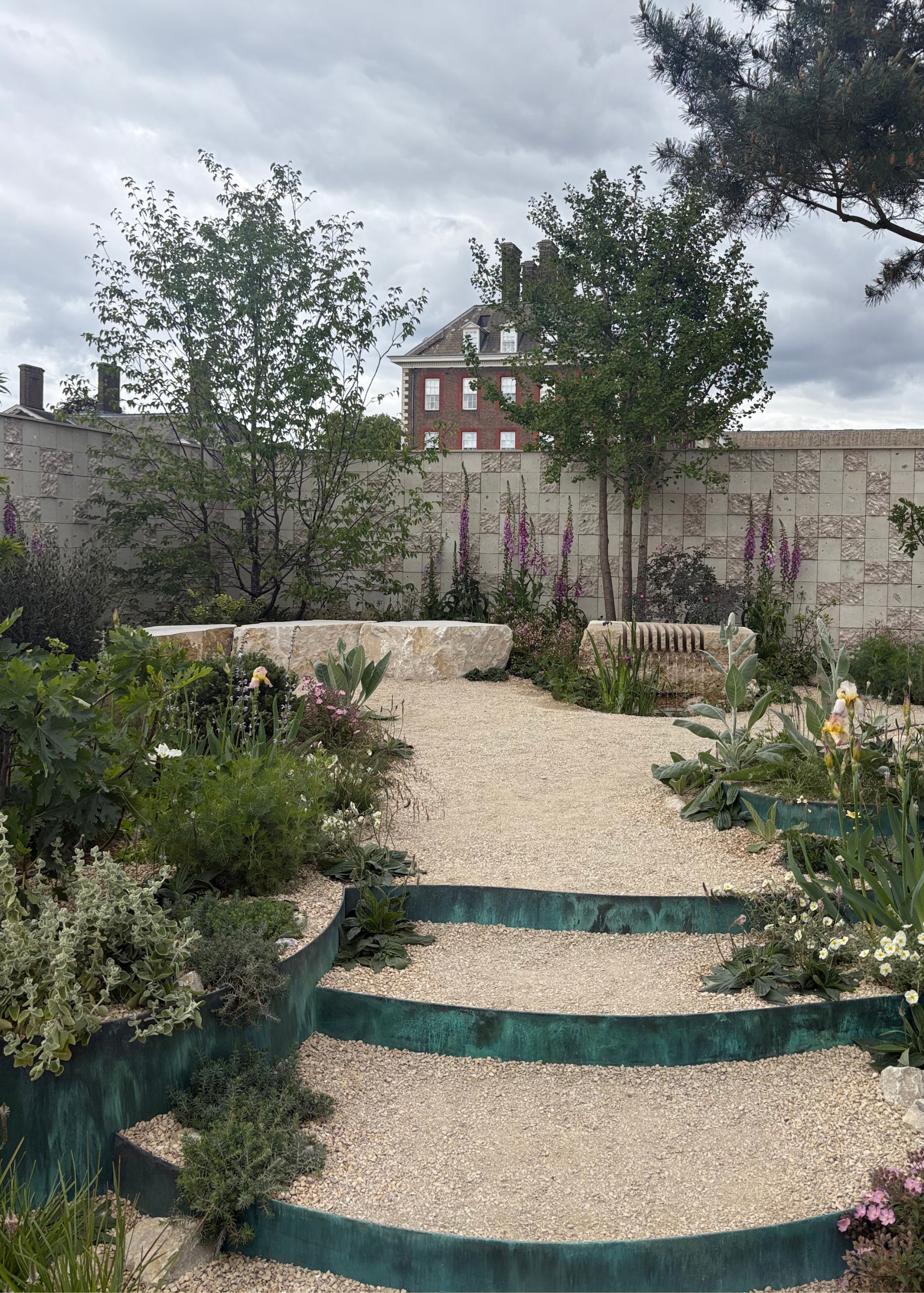 A sensory garden with layered planting, stone benches, and oystercrete walls at the Chelsea Flower Show 2026