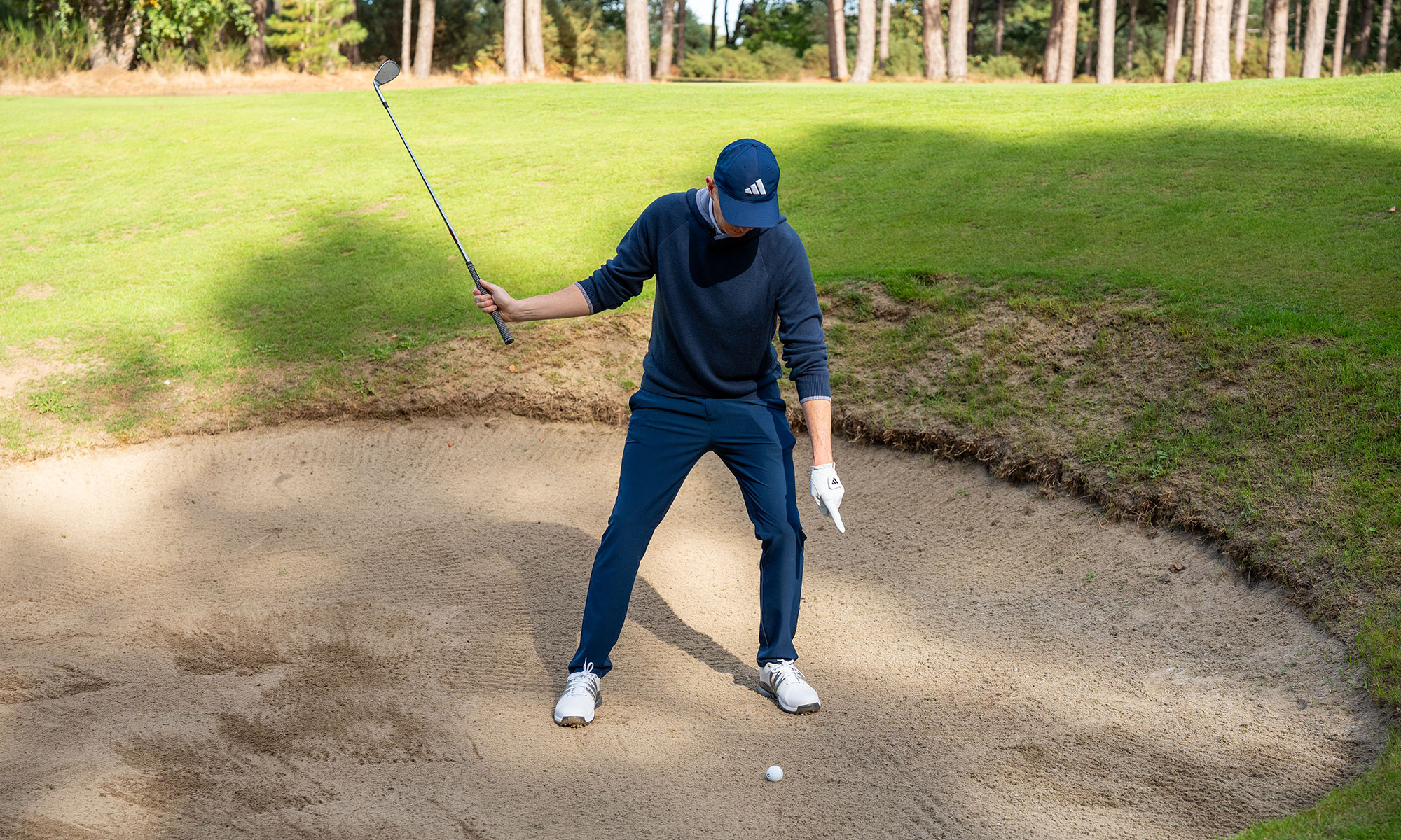 Ben Emerson pointing at the direction of pressure through the feet for a winter bunker shot
