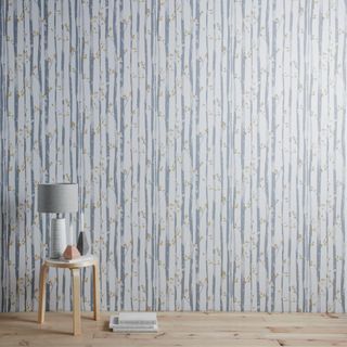 Blue and white floral striped wallpaper print with wooden stool and lamp
