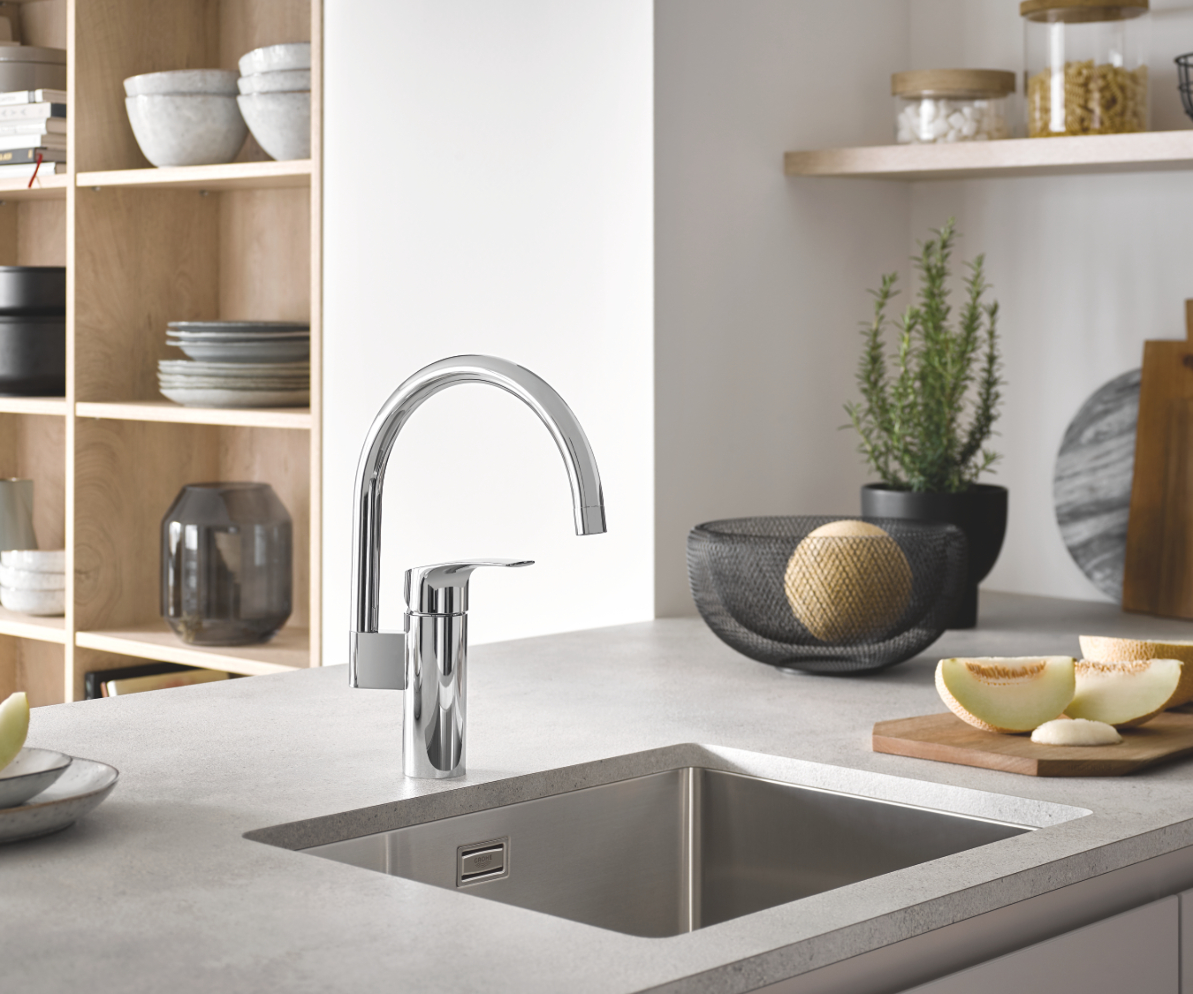 kitchen with swan neck silver tap over cut-out sink in light grey kitchen worktop