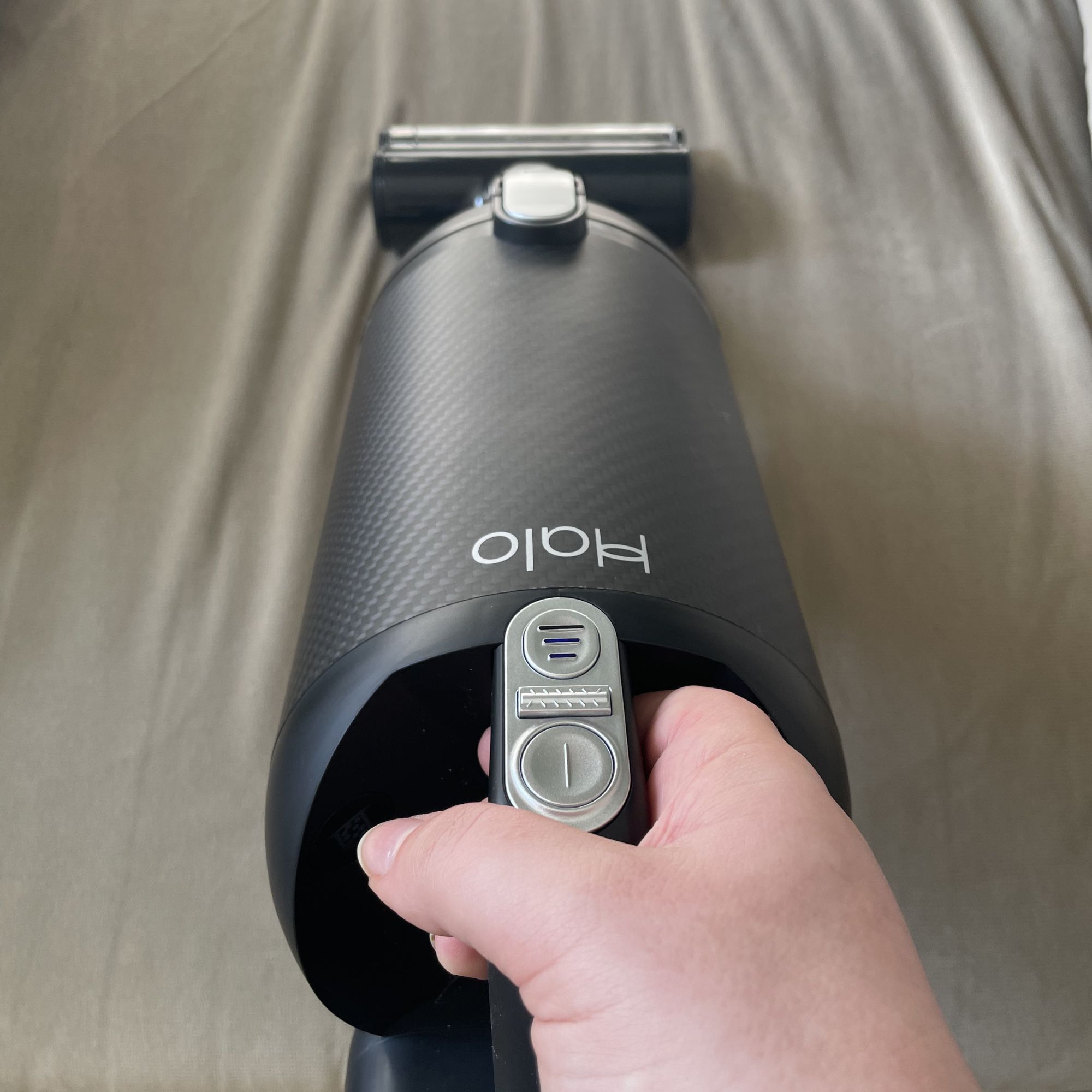 Using the Halo Capsule XR handheld to vacuum a grey sofa