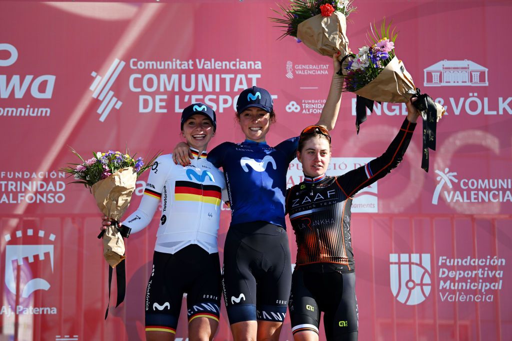 VALENCIA SPAIN FEBRUARY 05 LR Liane Lippert of Germany and Movistar Team on second place race winner Floortje Mackaij of The Netherlands and Movistar Team and Nikola Noskov of Czech Republic and Zaaf Cycling Team on third place pose on the podium ceremony after the 5th VCV Fminas GP 2023 a 93km one day race from Paterna to Valencia on February 05 2023 in Valencia Spain Photo by Dario BelingheriGetty Images