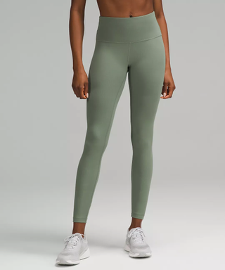 Lower half of a female model wearing green sports leggings