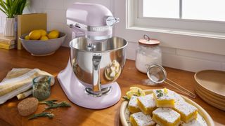 KitchenAid Wildflower stand mixer on wood countertop next to cake slices on a plate