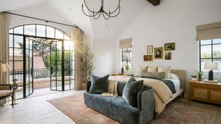 bedrom with vaulted ceiling, white walls, large bifold windows