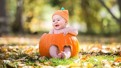 Baby Halloween costume 2021—a baby sitting in a pumpkin