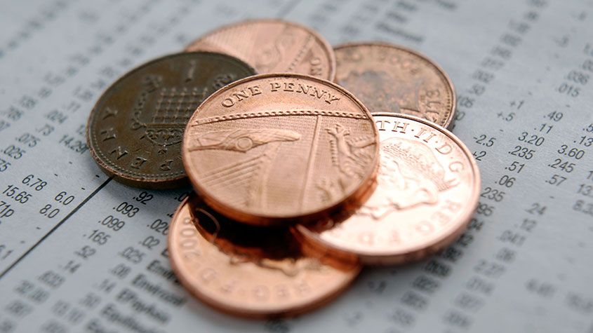 Pile of pennies on newspaper stock price page 