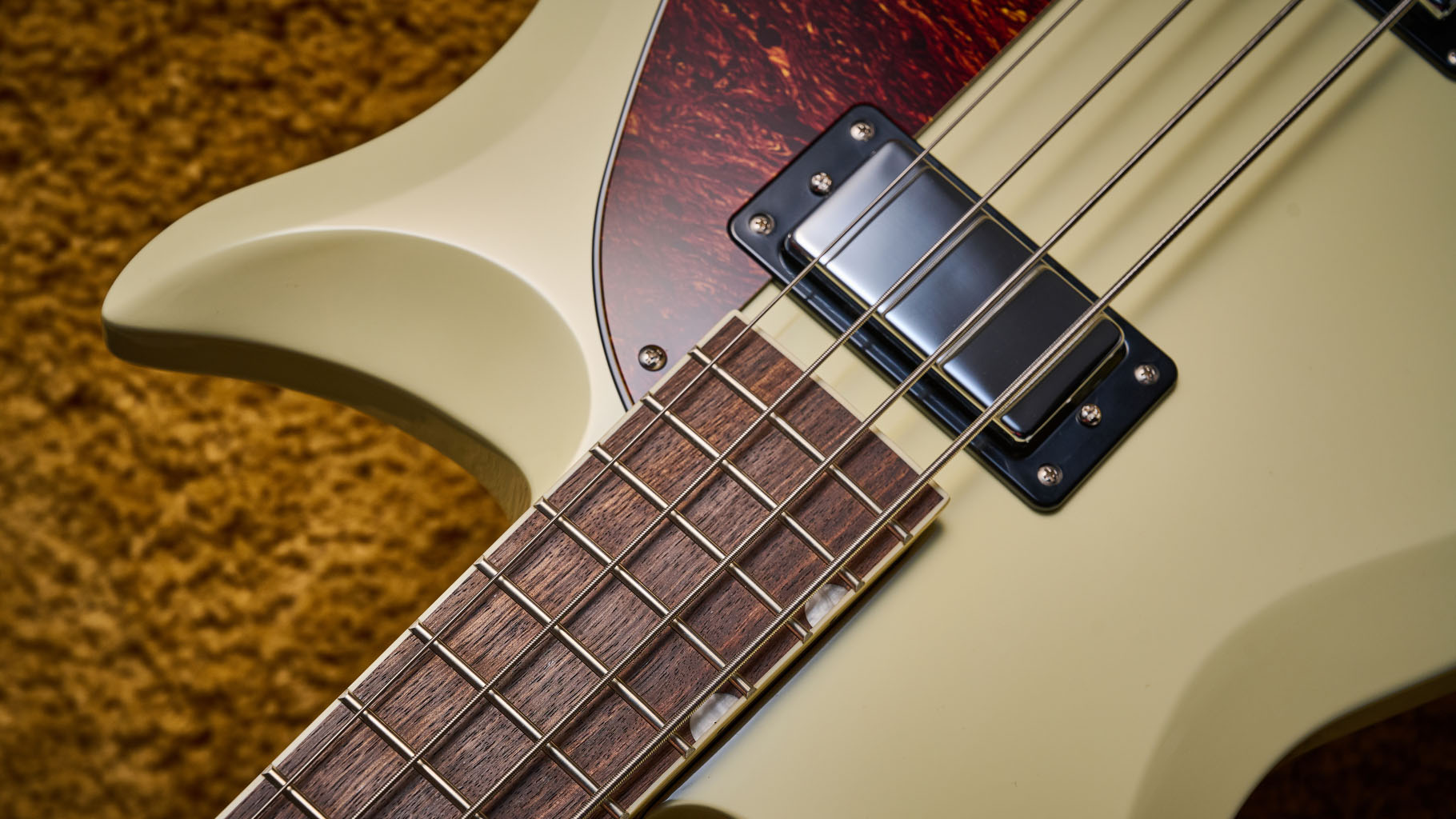 Gretsch Electromatic CVT Bass Double-cut: the retro-styled cream-colored four-string is pictured in close-up against a shaggy brown carpet.