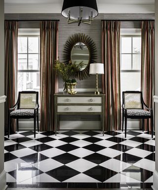 A hallway lighting idea with lampshade pendant, table lamp and checkered floor