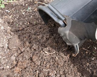 Adding compost to soil to make it richer