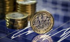 British one pound coins on a financial graph background