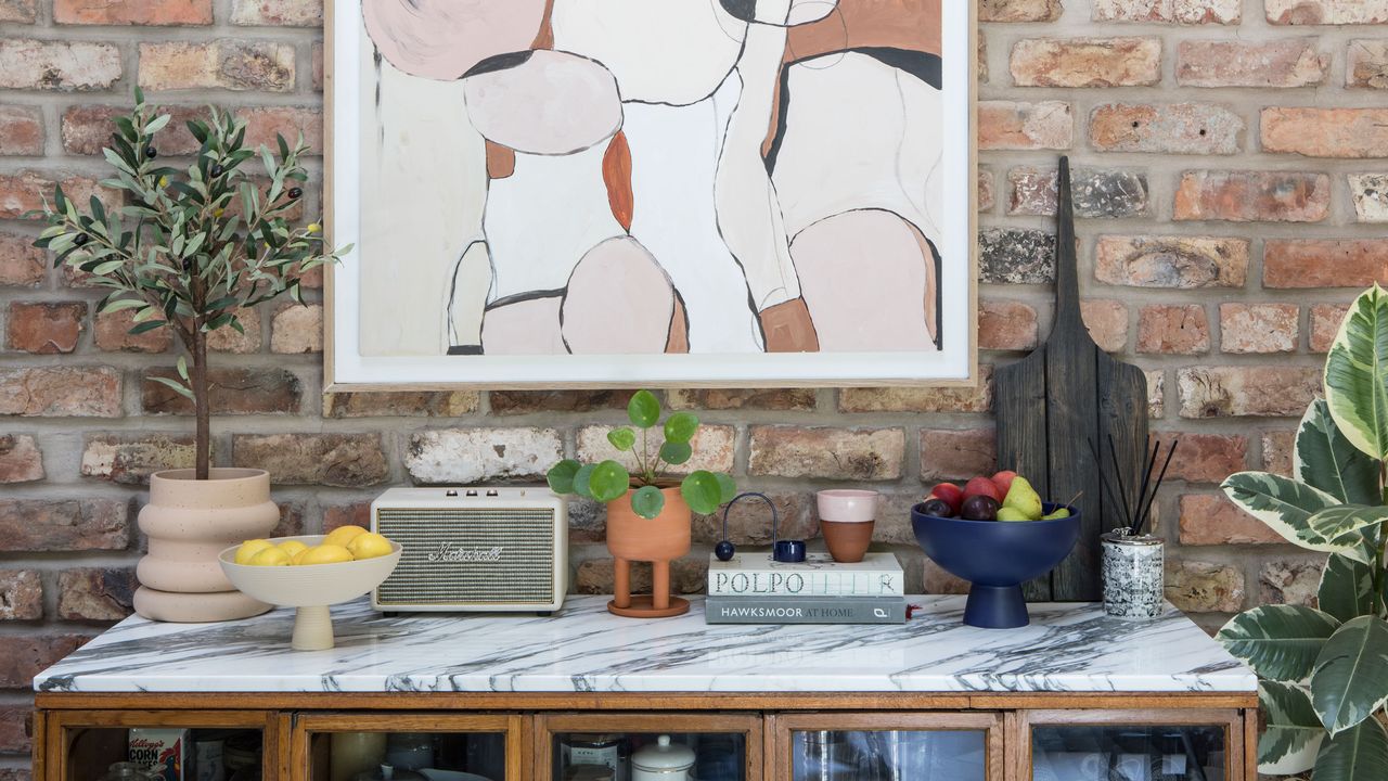 side board with decorative objects, artwork and exposed brick wall