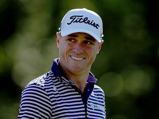 Justin Thomas smiling toward the camera with his Titleist hat on