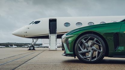 green bentley car in front of private jet