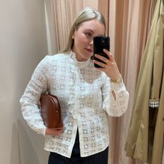Florrie wears a lace blouse from Sezane, pinstripe trousers and carries camel handbag