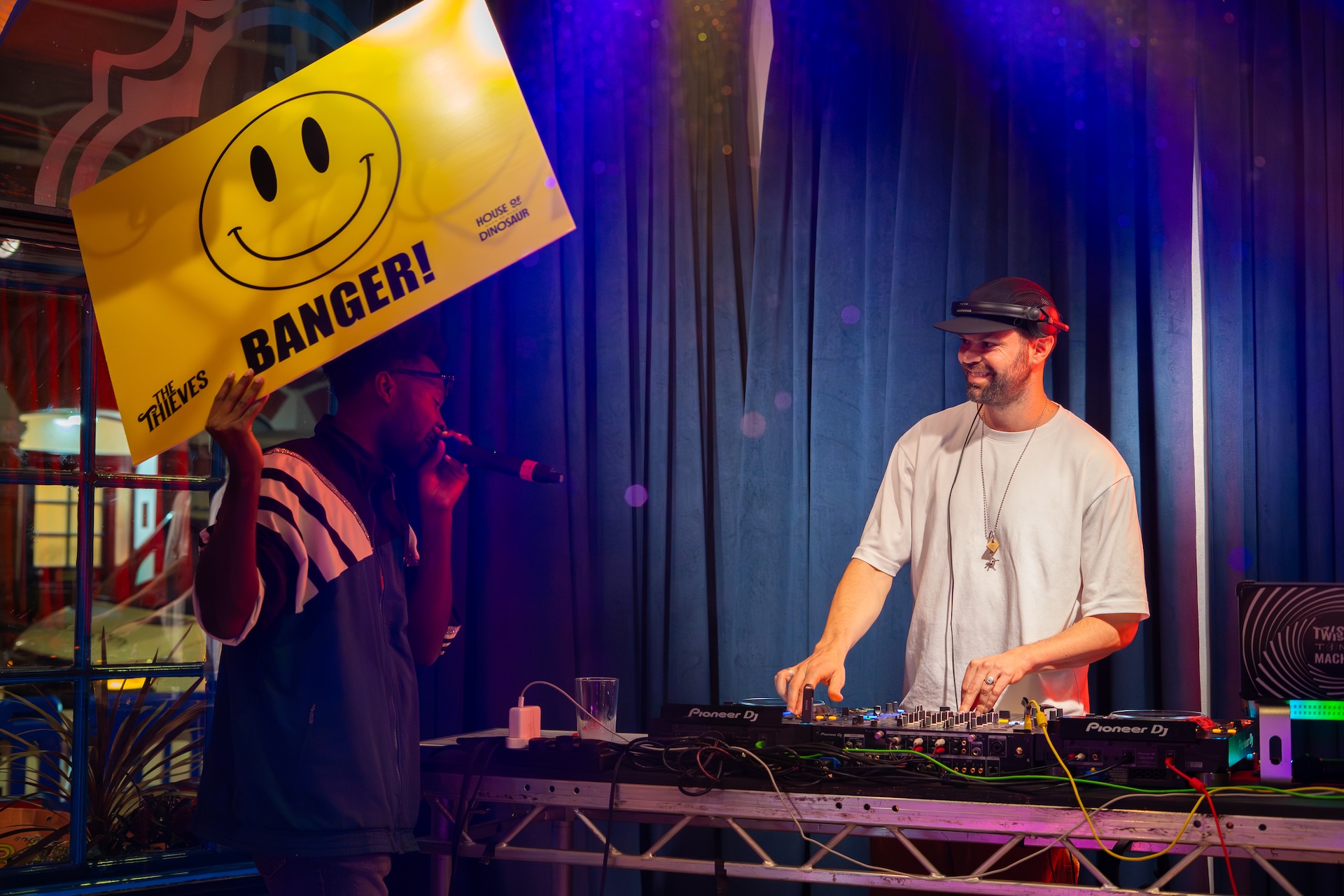 The Thieves DJ and a man holding up a banger sign