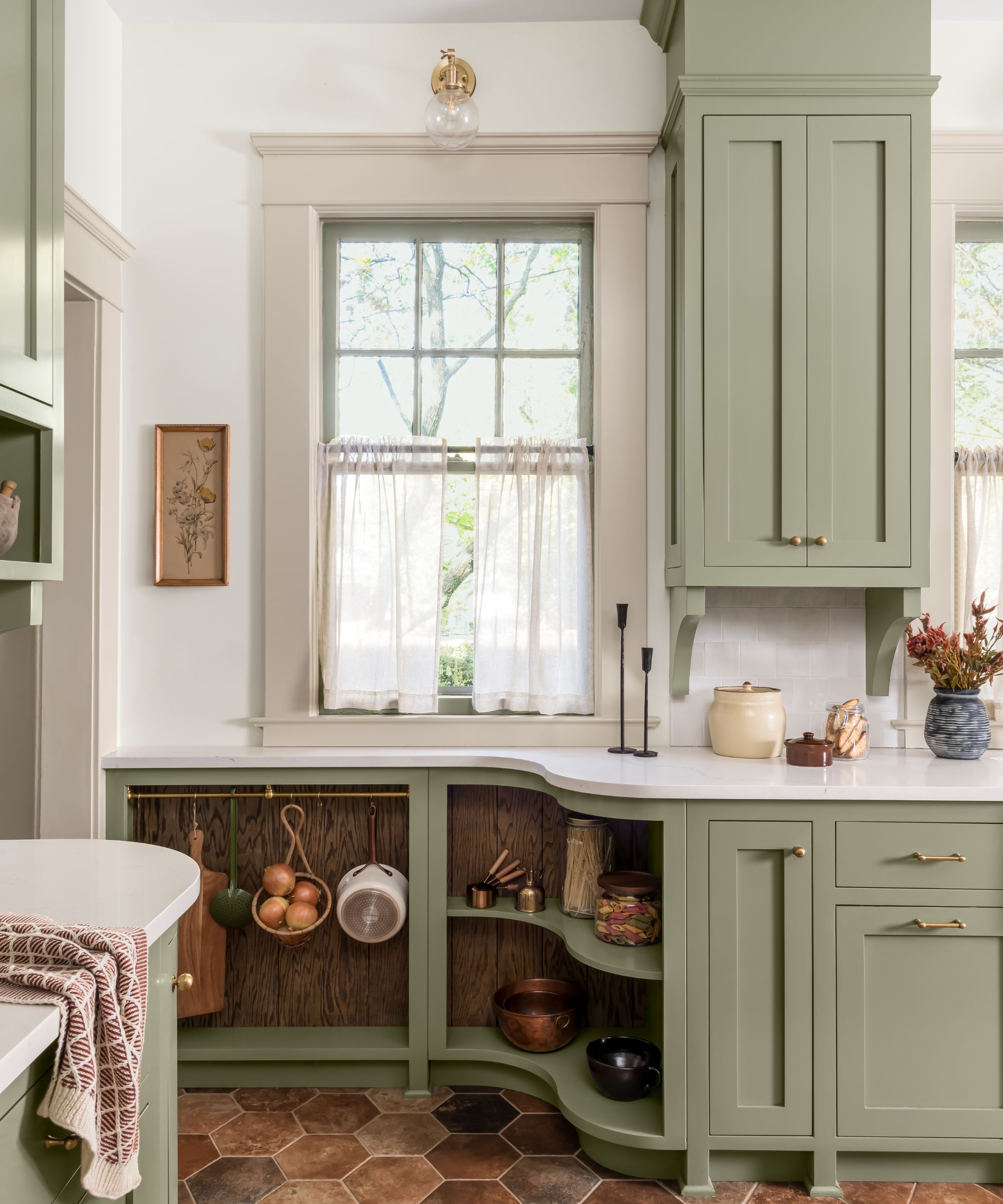 A small green kitchen with custom storage to cater to the narrow walkway