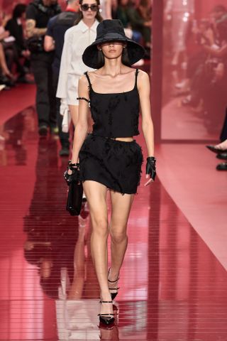 A Gucci runway model wearing an all-black outfit in the spring/summer 2025 collection.