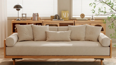 a living room with a tan couch and a credenza with decor on top