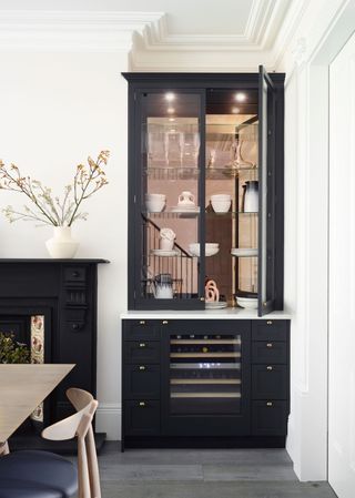 a kitchen with a glassfronted cabinet with downlights