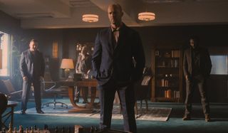 Jason Statham and his criminal associates stand in his office in Wrath of Man.