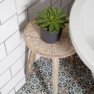 bathroom with white tiles on wall and potted plant on stool
