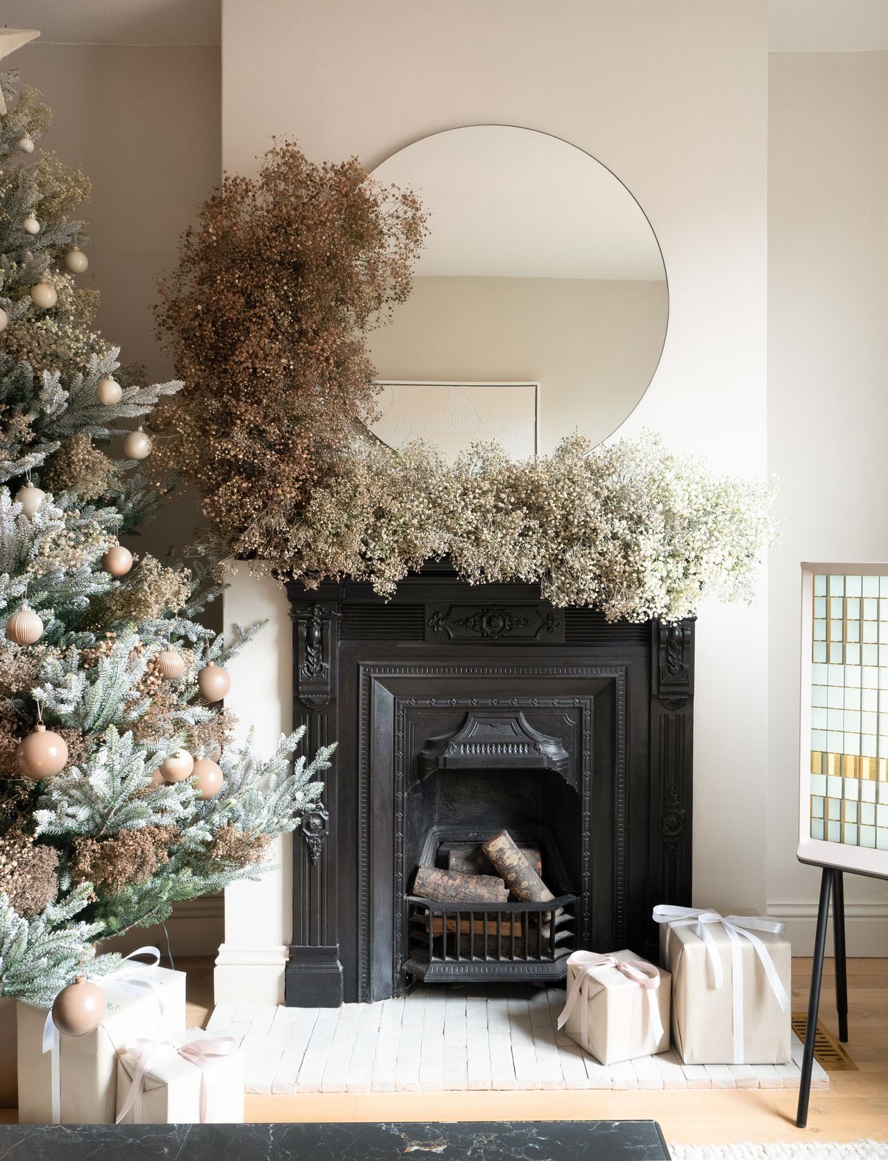 a living room mantel covered in gypsophila for christmas decor