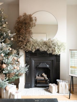 a living room mantel covered in gypsophila for christmas decor