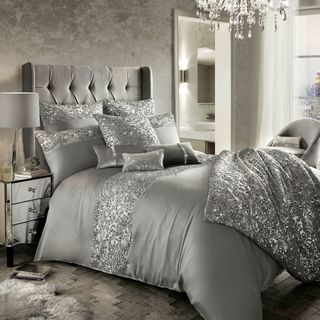 grey bedroom with satin cover and grey drawers