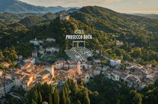 Ariel shot of the hills of Asolo with green trees and white buildings