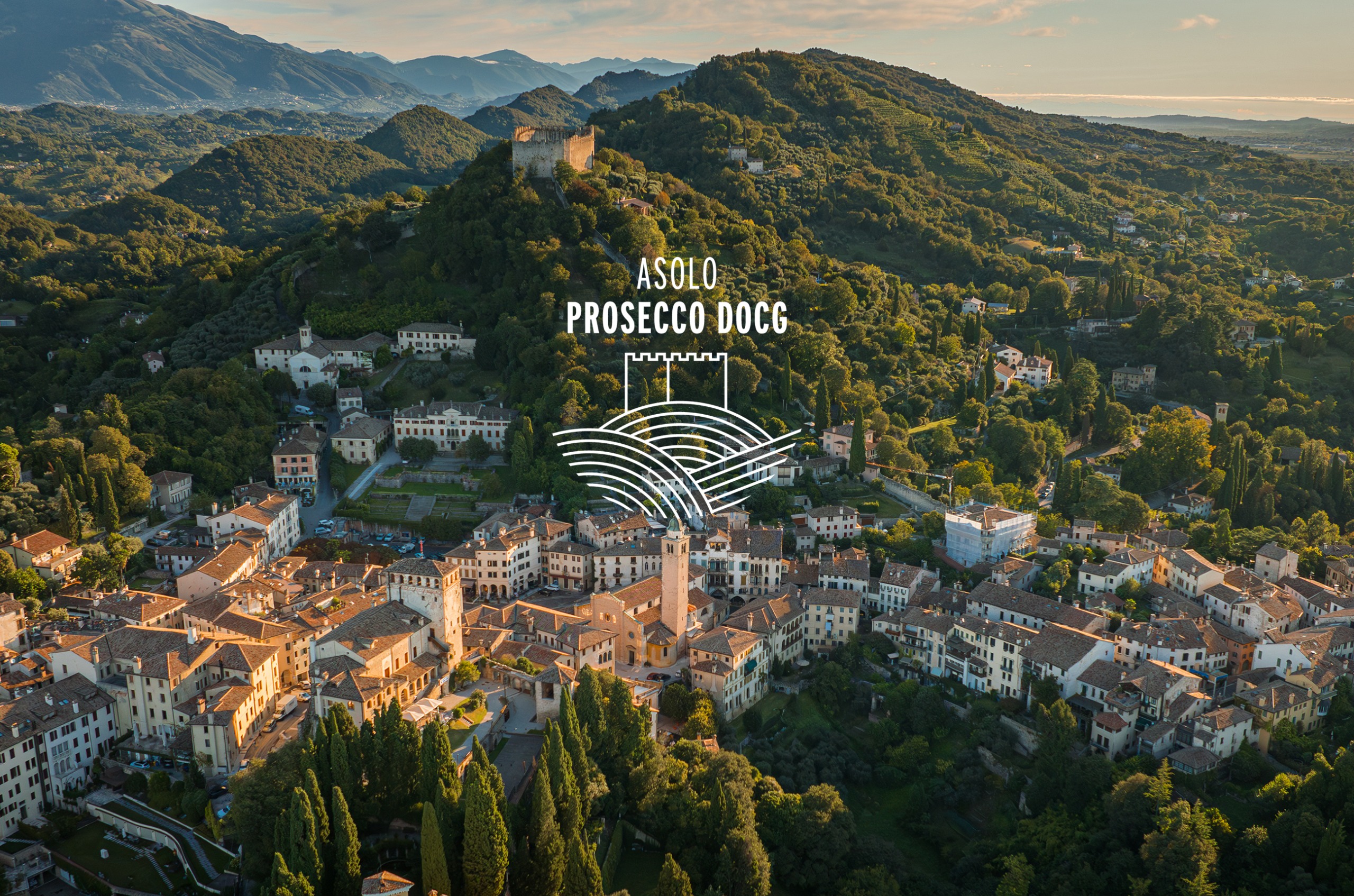 Ariel shot of the hills of Asolo with green trees and white buildings