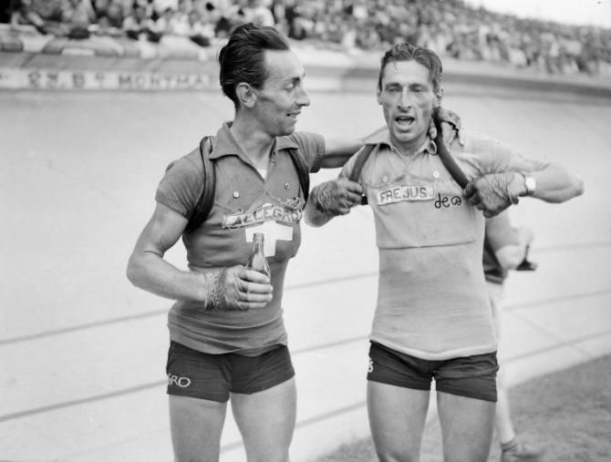 Swiss Ferdi Kubler (R) is congratulated by one of his compatriots, 07 August 1950 at the Parc des princes in Paris, after winning the Tour de France.