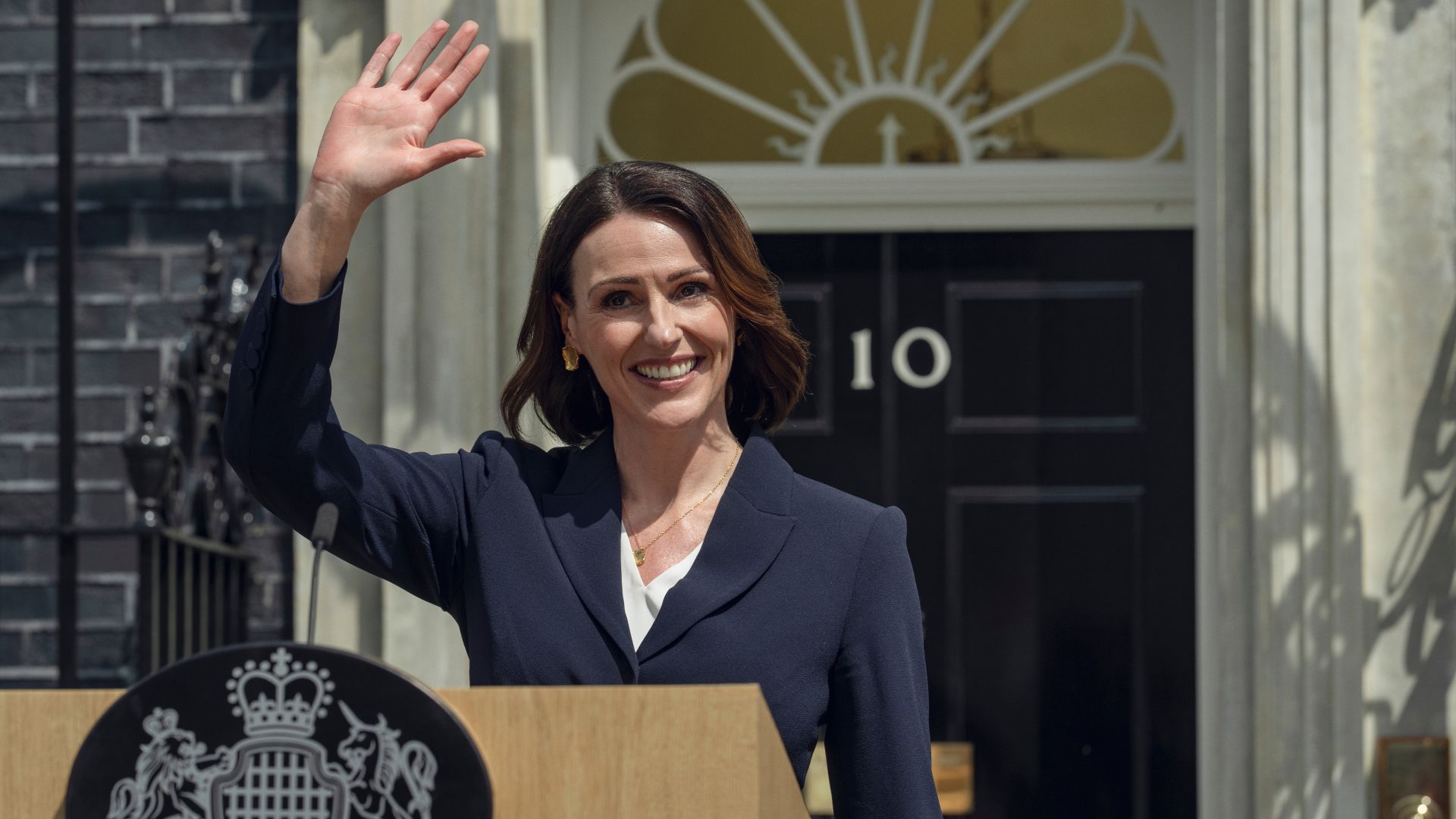 Suranne Jones waves outside Number 10 Downing Street while standing at a lecturn