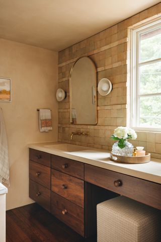 a beige tiled bathroom with storage