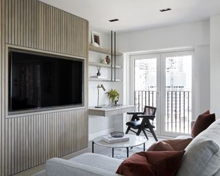 Wooden paneling in the living room with white sofas and an open window