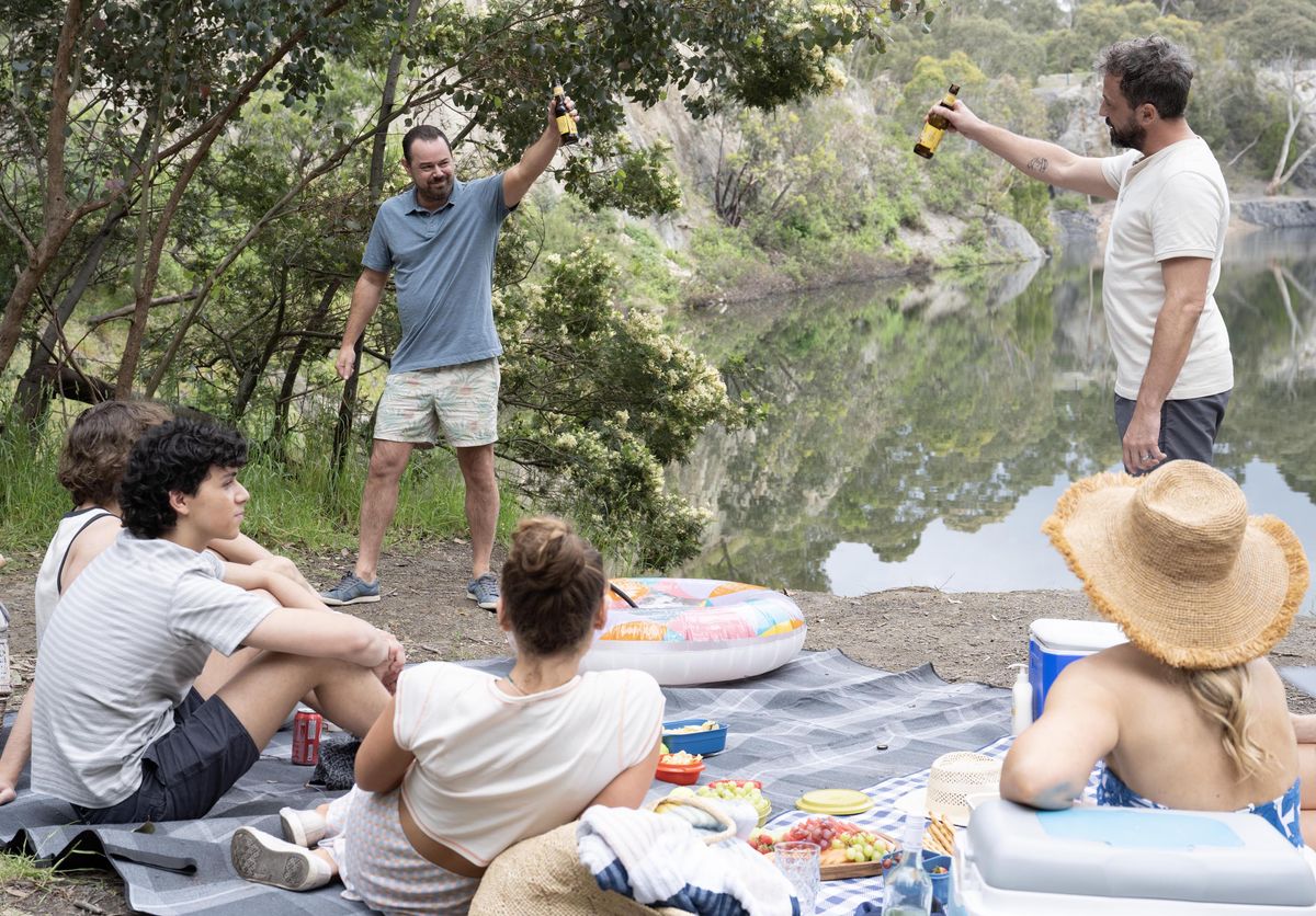 Heat cast sitting on a picnic blanket with Danny Dyer toasting with a beer. 