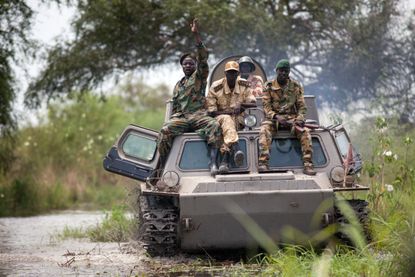 Soldiers of the Sudan People Liberation Army cross the Nile River on a tank near Malakal, northern South Sudan.