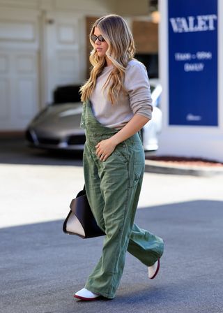 Sofia Richie Grainge wears green overalls with a gray sweater