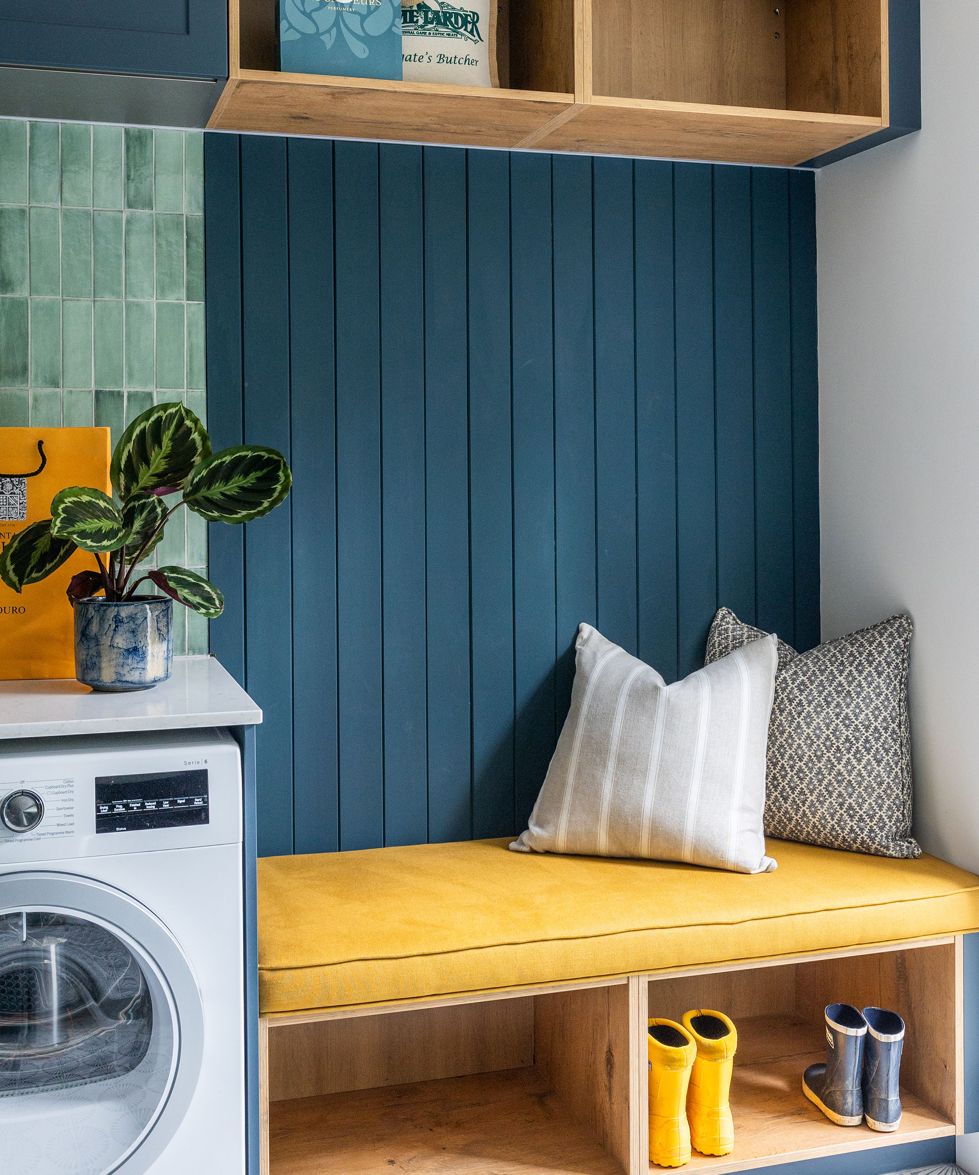 boot room with blue wall panelling and storage bench