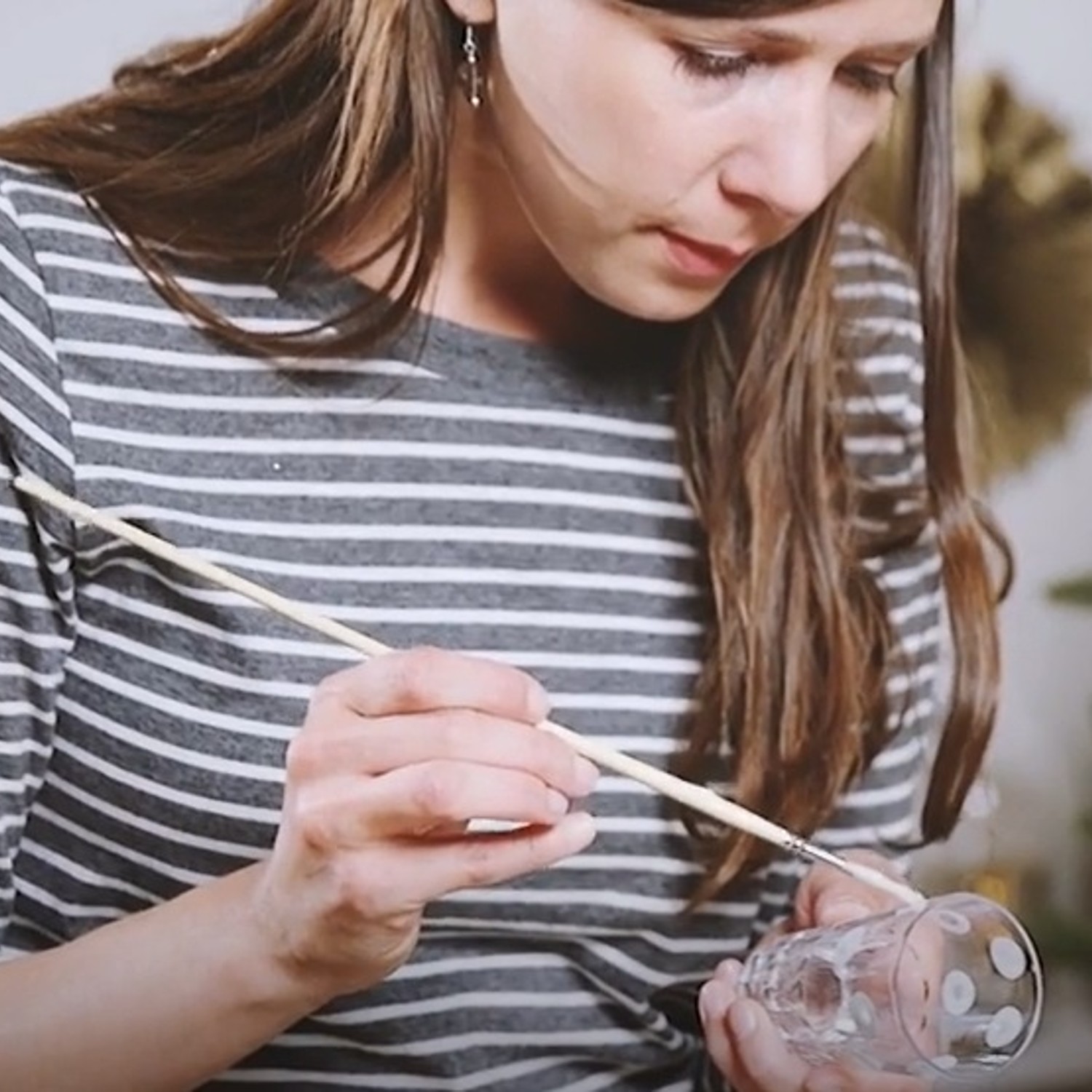 lady with paint brush on glass