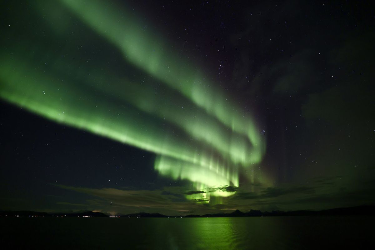 green aurora sweeps through the sky like long swirling ribbons of light.