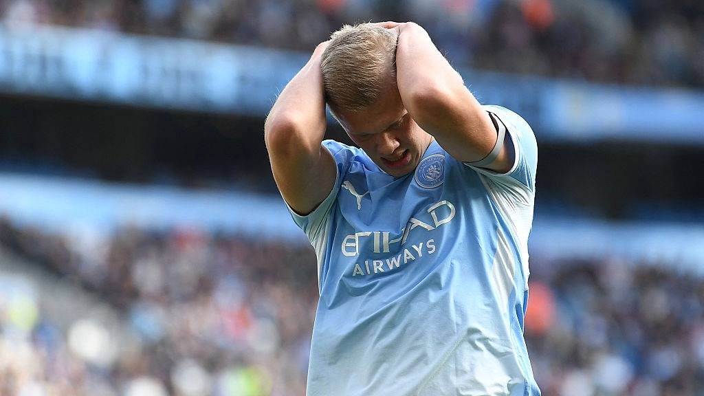 Erling Haaland puts his head in his hands during a Manchester City match.