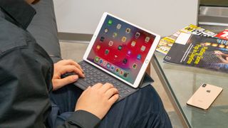En person som sitter med en iPad Air 2019 i knät och skriver på tangentbordet.