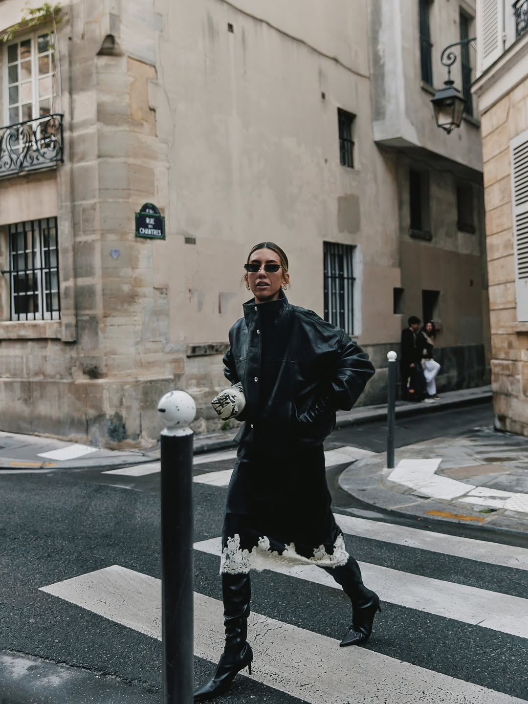 Hannah Lewis Stylist wearing a black Rohe jacket with a lace skirt and leather boots.