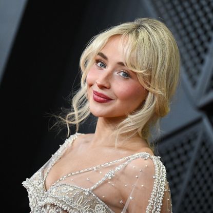 a young blonde woman taking photos on the grammys red carpet