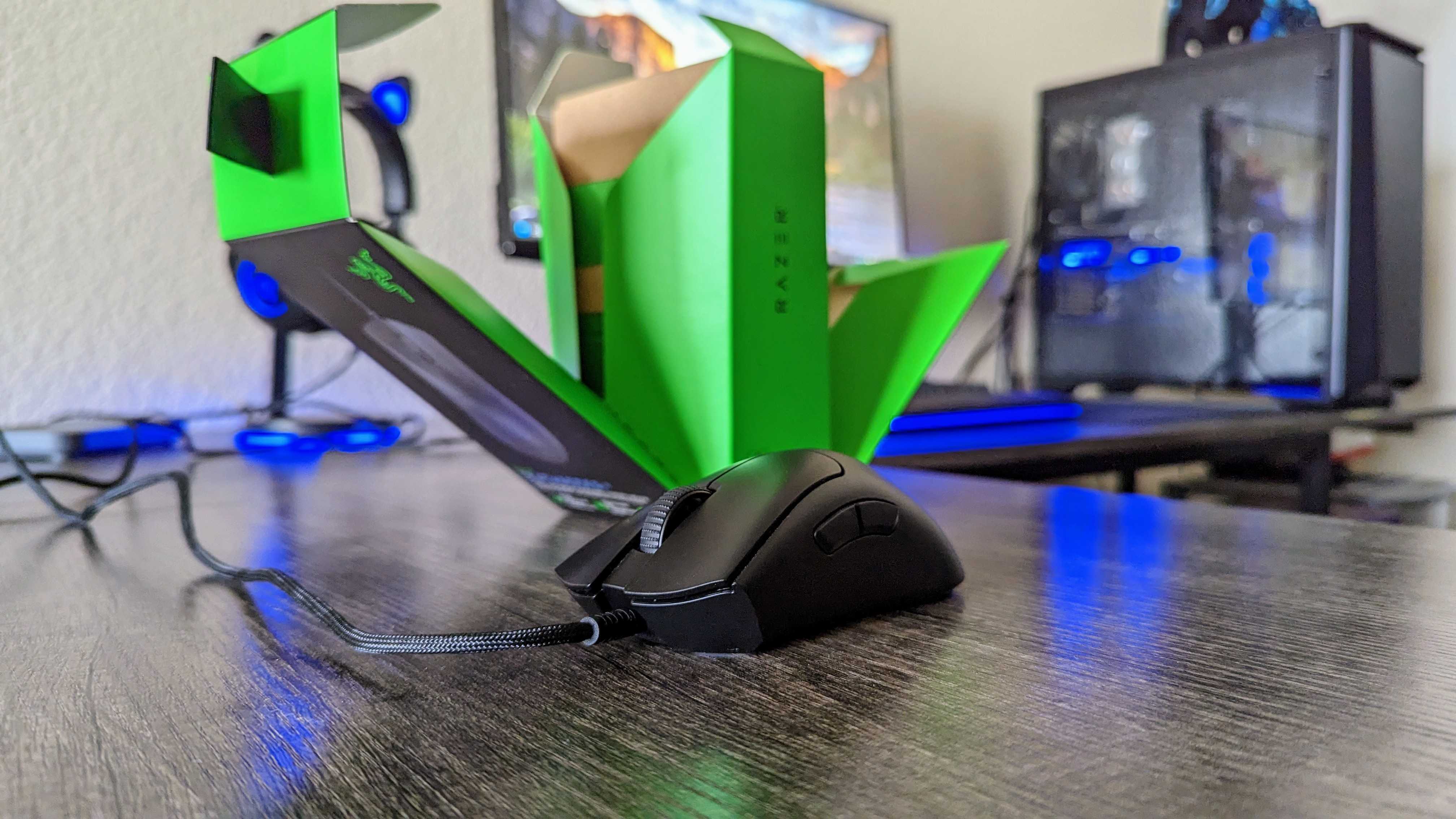 The Razer DeathAdder V3 on a desk, with its retail box open behind it.