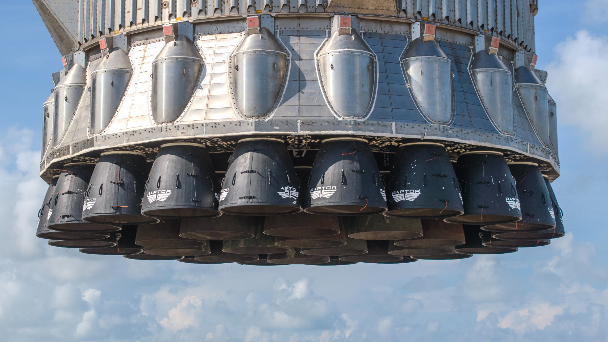 a closeup photo of a rocket's base, showing dozens of engines